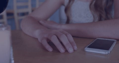 clip-3998747625-woman-sliding-hand-near-phone-on-table