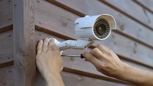 Técnico que instala un sistema de seguridad con cámara CCTV inalámbrica en la casa.