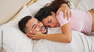 Man and woman couple lying on bed hugging each other sleeping at bedroom