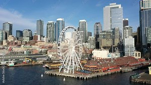 Birdseye footage of the Seattle Great Wheel with the waterfront, Belltown, the Seattle Aquarium, Alaskan Way with few people downtown, the commercial district of Seattle, Washington during COVID