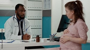 General practitioner having conversation with pregnant patient in medical office, doing checkup consultation. Male doctor giving pregnancy and maternity advice to expectant woman.
