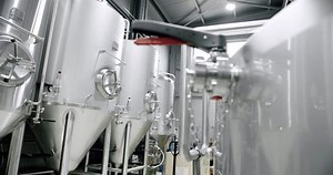 Huge stainless vats in a brewery. Equipment for beer fermentation. Brewing equipment. Factory, brewery concept. Large reservoirs, tanks and pipes with manometers in private microbrewery.