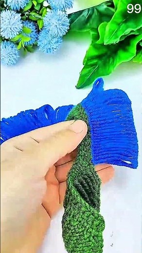 Crochet hook loops blue yarn, green edging borders neat handmade textile pattern