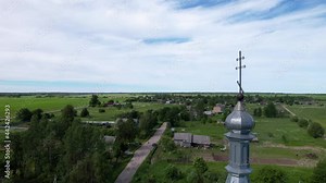 Old abandoned Russian church built in 1870. Camera slowly flies down near the cross on the church's top. A authentic Russian village can be seen in the background.
