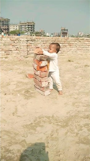 Chid building a pyramid with brick.