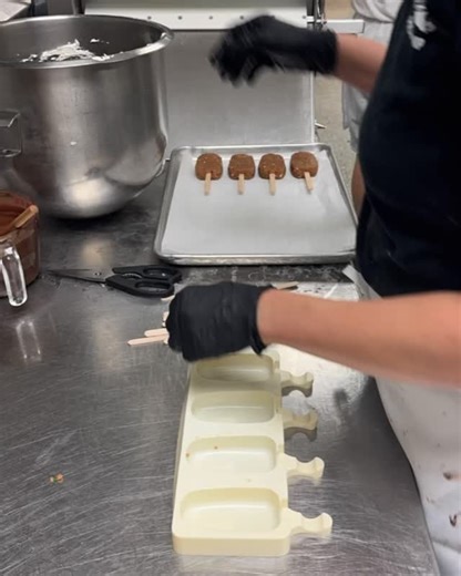 Changing up my cake popsicle process… I’ve seen a bunch of videos of cake popsicles being made this way (in an at home setting) so I thought I’d give it a try and see how it did in a bakery setting. I mixed cake crumb and a little bit of bc to get the right popsicle consistency, formed them into each mold, placed a stick in each one then placed them on the pan. While I was melting the chocolate, I did put the pan in the freezer for about 15 minutes to chill the pops. Long enough to firm them up 