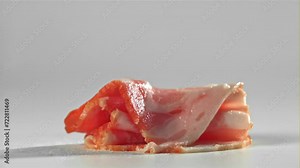 Bacon falling on white background. Filmed on a high-speed camera at 1000 fps. High quality FullHD footage