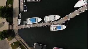 Charter boat takes out fishermen to catch Salmon and Lake Trout on Great Lakes Lake Michigan fishing trip in Charlevoix Michigan looking down on boats tied to dock