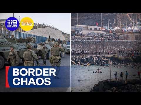 Thousands of migrants flood Spanish border control point | 9 News Australia