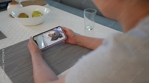 Mother using ip wireless security camera as baby video monitor on mobile phone, woman watching her sleeping baby in real-time. High quality 4k footage