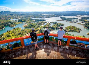 GUATAPE, COLOMBIA: COULD this rainbow-painted town be the most colourful place in the world? Stunning video and pictures have revealed the spectacular town where everything from the buildings to the steps are painted in bright, vibrant colours. The incredible images have a surreal feel as the multi-coloured houses stand in stark contrast to the aerial view of the lush green surrounding area. The snaps were taken in Guatapé, Colombia by Canadian photographer Jessica Devnani (27) from Toronto usin