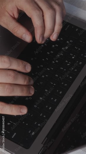 Vertical close-up video of hands typing rapidly on a laptop keyboard, showing quick movements and fast-paced workflow. Detail shot focused on productivity and deadline-driven activity. High quality 4k