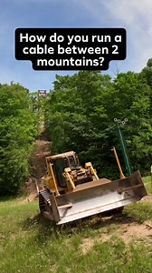 How do you run a cable across two mountains? The cables will be supporting the world's longest timber-towered suspension bridge at @boyne.mountain #SkyBridgeMichigan opening 2022. We used a Cat D6T dozer to pull two 3 inch braided steel cables 1000 feet between the mountaintops. Getting the SkyBridge one step closer to completion. #teamelmers #boynemountain #d6t #catd6t #catequipment #caterpillar #caterpillarequipment #skybridge #boyneskybridge #michigan #dronefootage #constructionwork #construc