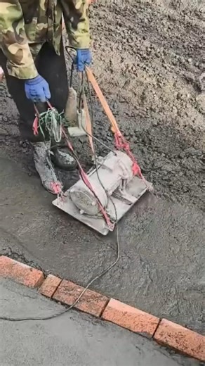 smoothing wet concrete floor surface using a heavy electric plate compactor machine