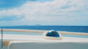 Soft focus yacht compass with Curacao landscape in distance beyond Caribbean Sea