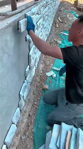 Installing decorative stone wall cladding with cement and trowel