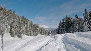 snowmobiles up hill and makes powder turn with Grand mountains in background. Pro snowmobiler, Winter fun moto extreme