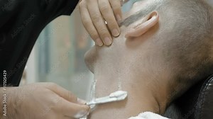 The barber is shaving his client in old fashion manner. Single blade shave gives the best result. Grooming is necessary for men and woman.