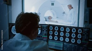 In Medical Laboratory Patient Undergoes MRI or CT Scan Process under Supervision of Radiologist, in Control Room Doctor Watches Procedure and Monitors Brain Activity.