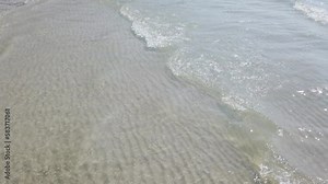 Top view sea waves motion, Beach and sea, Looping ocean surface texture over tropical sandy beach and waves, Sunset beach, Soft wave of sea on sandy beach. Background, Soft focut.