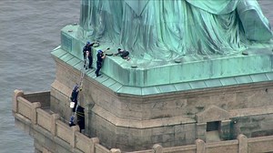 Woman climbs base of the Statue of Liberty