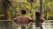 Young adult couple in love swimming together in open-air infinity...