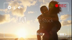 Man giving piggyback ride to woman over camera recording animation at sunset beach