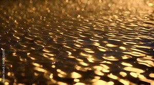 Abstract golden liquid texture with flowing, rippled patterns and a metallic sheen, creating a luxurious and shiny visual effect.
