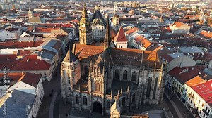 Fly around St. Elisabeth Cathedral in Kosice, Slovakia, during autumn sunset hours with scenic rooftop views of the cityscape. Sunset aerial view of Kosice, Slovakia