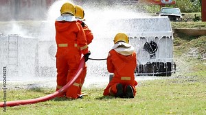 Firefighter fighting with fire flame protection property. Fireman wear hard hat, body safe suit uniform for protection from fire operation. Rescue trained in fire fighting extinguisher hazardous fires