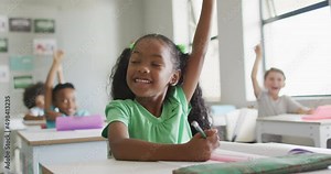 Video of happy african american girl raising hand during lesson