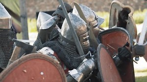 Medieval knight battle. Warriors in full plate armor with melee weapons. Armed men fighting. Real historical warfare reenactment