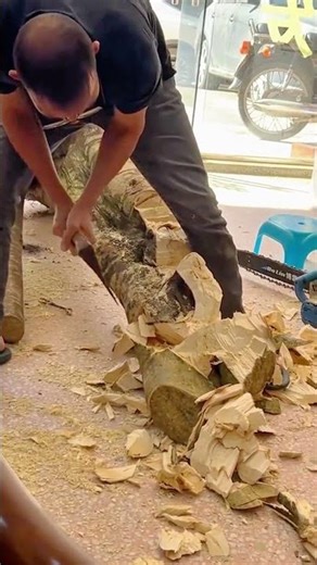 Carving large tree trunk using hand chisel and hammer