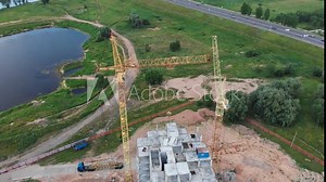 Tower crane builds a residential building near a reservoir. Construction of buildings, construction site.