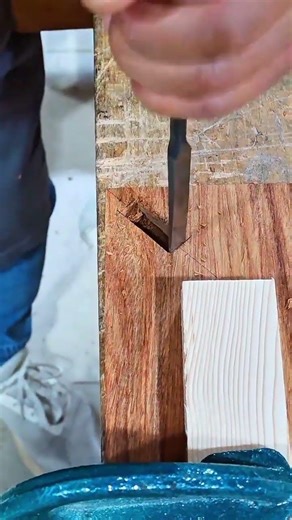 Woodworking using a chisel to carve a small rectangular slot in a piece of wood for joinery