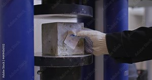 Close-up, a concrete sample is inserted into a pressing machine. Testing the strength of concrete in the laboratory. 4k, ProRes