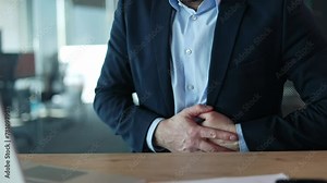 Close up of unrecognizable person typing on portable computer and having sharp spasm in abdominal area. Caucasian male in formalwear rubbing belly while having severe pain and digestion problems.