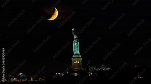 23.4 percent waxing crescent moon sets behind Statue of Liberty in New York City