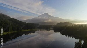 Trillium Lake drone aerial cinematic Mount Hood Oregon reflection calm water snow ski trails early morning golden yellow sunrise stunning beautiful peaceful fishing camping canoeing forward movement