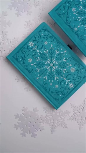 ❄️ Our Winter Collection is coming November 5th, and here’s the first design: Frosted Storybook ✨ This notebook features an intricate full cover snowflake design, part debossed and part hand stamped with silver foil on a teal vegan leather cover 🌨️ All our Winter Collection notebooks come in white dot grid pages in a choice of B5, 8x8, A5, TN, and B6. Lined and blank page options are also available in A5 for each design 📚 Do you get snowfall where you live? 🌨️☃️ [Video description: showing th
