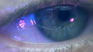 Reflection in the eye of the monitor screen when watching a movie. Extreme closeup