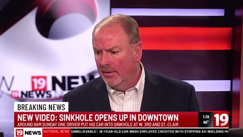 Car nearly falls into massive sinkhole