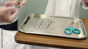 A close up shot of a nurse handing a medical instrument to a doctor during surgery.