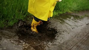 clip-7223452-young-child-jumping-splashing-mud-puddle-road