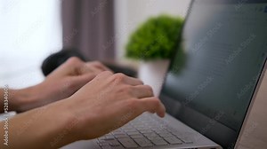 Hands typing on a laptop