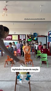 Siga o boneco Como funciona: 1. Cada aluno ficará com sua cadeira, posicionada de forma organizada no espaço. 2. A professora estará na frente, com o boneco e uma cadeira. 3. A professora realiza ações com o boneco, e os alunos devem imitar exatamente o que ela fizer. • Exemplo de movimentos: • Colocar o boneco ao lado da cadeira → alunos ficam ao lado da cadeira. • Colocar o boneco sentado na cadeira → alunos se sentam. • Fazer o boneco dar uma volta ao redor da cadeira → alunos imitam o movime