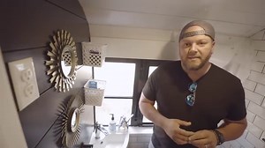 This family of five transformed a Thomas Saf-T-Liner school bus into a remarkable tiny home decked out in navy and white decor. The L-shaped kitchen has an abundance of storage and impressive appliances. In the spacious living room, you'll find a couch suited for several guests and a removable table providing more space when not in use. Momma gets her own vanity in the main bedroom, and the three kids decided on hanging monkey bars in theirs! They made the center hallway convert into a master ba