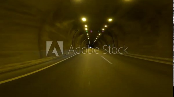 Driving through tunnel, video captures car in darkness. Experience of driving, car perspective inside tunnel highlighted. Focus on driving, car navigating through highway tunnel