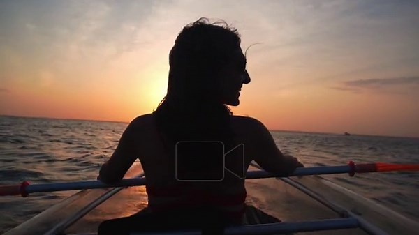 Silhouetted happy excited woman in a glass-bottom kayak watches a vibrant sunset over the ocean. High-contrast portrait capturing peace, wonder, relaxation. wellness and tropical maritime adventure Stock Video Footage - Alamy