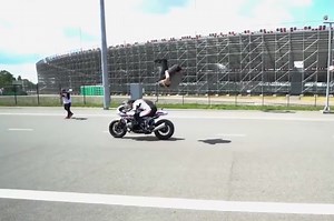 Daredevil parkour stuntman jumps over speeding motorbike